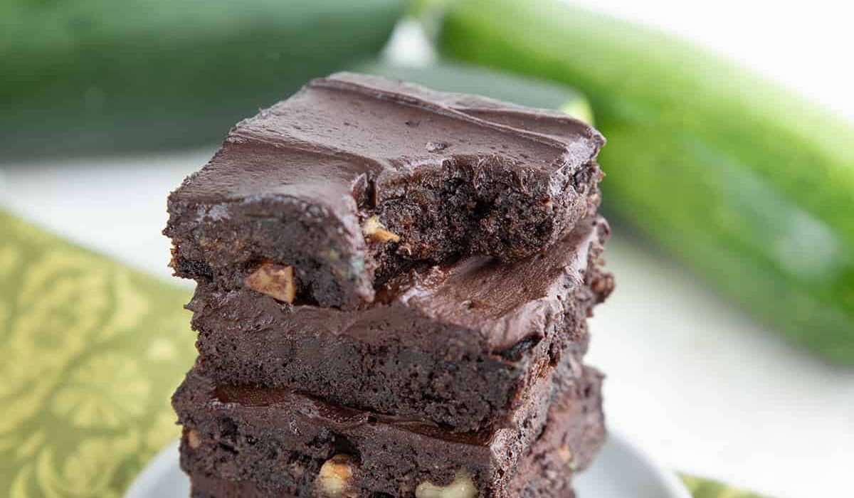 A stack of keto zucchini brownies with a bite taken out of the top one.