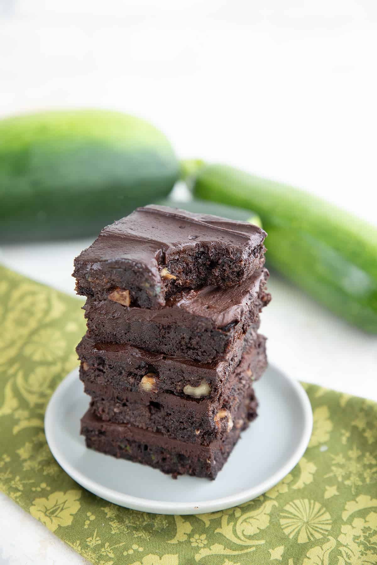 A stack of keto zucchini brownies with a bite taken out of the top one.