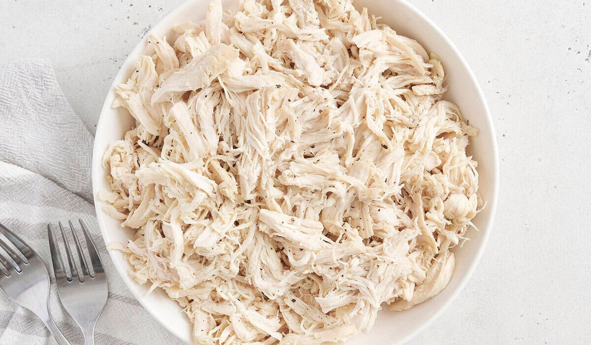 Overhead view of a bowl of pulled chicken.