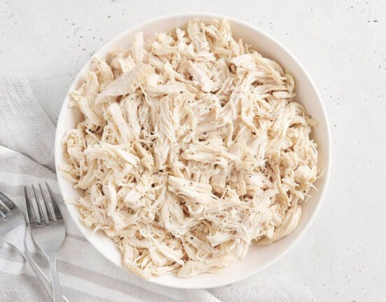 Overhead view of a bowl of pulled chicken.