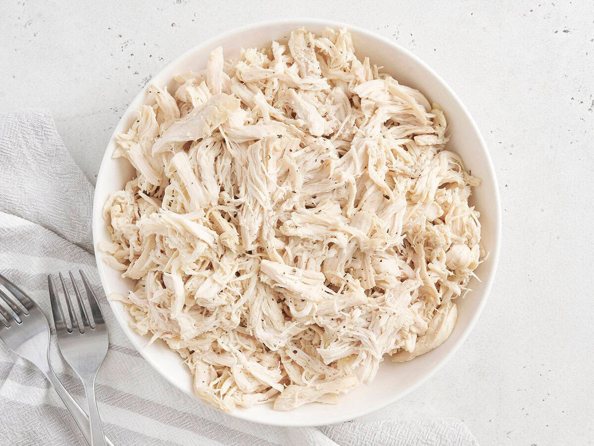Overhead view of a bowl of pulled chicken.